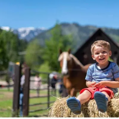 a little girl riding on top of a grass covered field